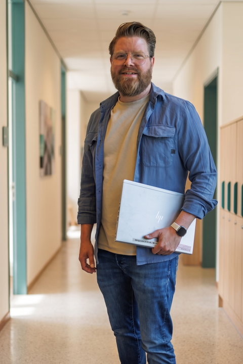 Ramon Visscher staat klaar in de schoolgang met laptop